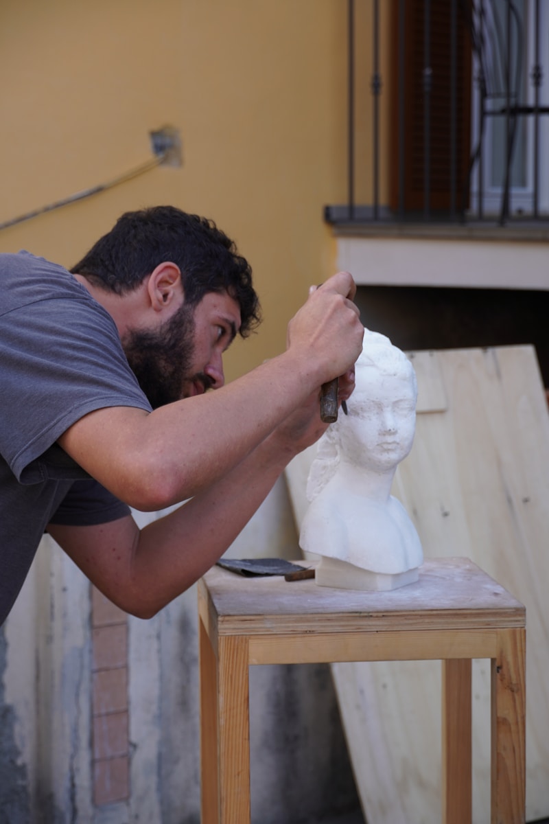 A man working on a statue of a head